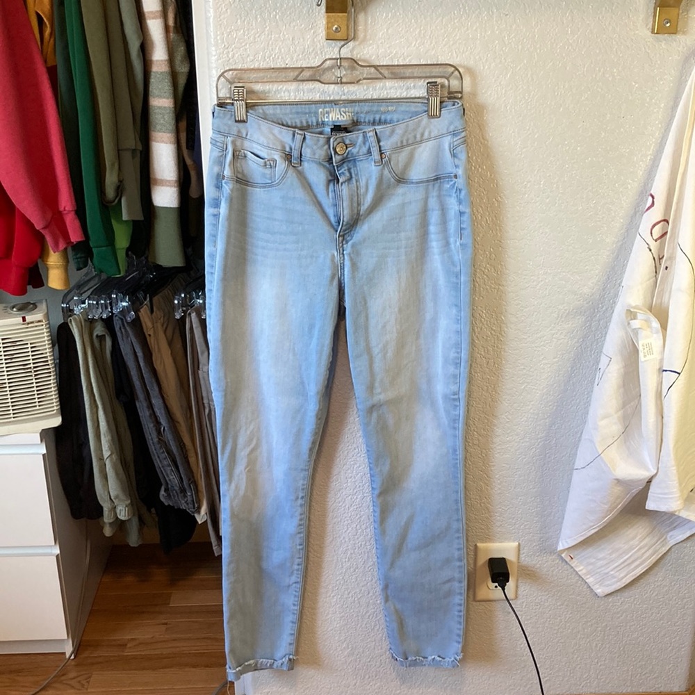 A pair of light wash mid rise skinny jeans